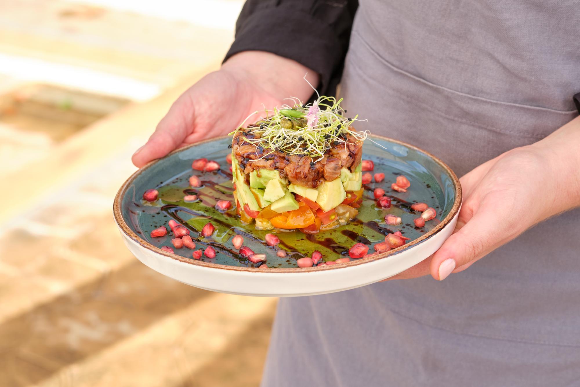 chef arranging a rustic plated meal on a wooden table
